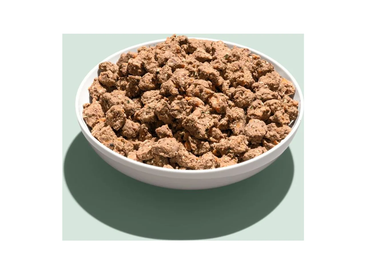A white bowl of Lyka Hypoallergenic Pro Goat fresh dog food on a pale green background.